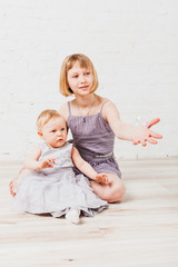 Two siblings sitting on floor 