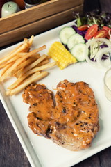 Pork steak set placed on a wooden table restaurant.