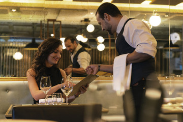 Young attractive woman making order at restaurant