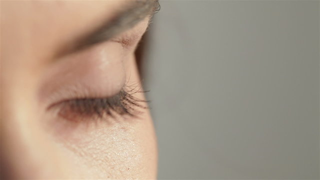Close up of a green woman eye isolated on a gray background