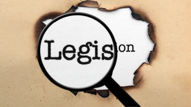 Magnifying glass on legislation paper hole 