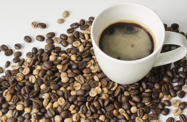 Coffee in cup and coffee beans on white background