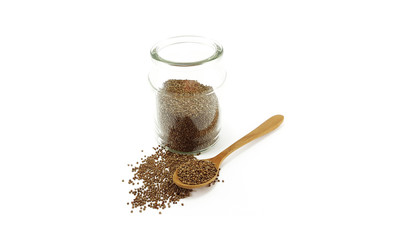 Perilla seed in glass jar with wooden spoon; white background