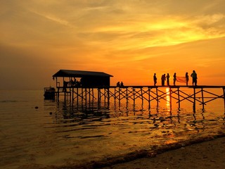 people on the old pier during sunset