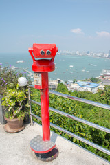 Coin-operated binoculars with pattaya beach in background