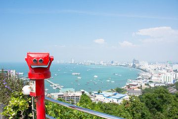 Coin-operated binoculars with pattaya beach in background