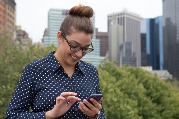 Young professional woman texting in the city
