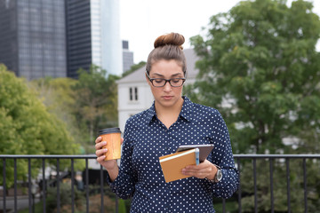 Young professional woman in the city in the city, hands full
