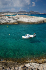 Fototapeta na wymiar Small fishing boat in Mytakas bay on the northern coast of Milos island.