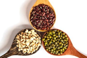 Legumes in a wooden spoon placed on a white background