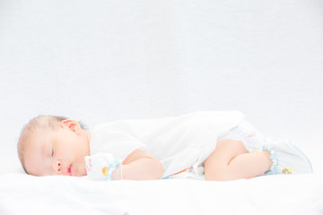 Peaceful baby lying on a bed while sleeping.