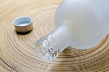 Close up of white  glass bottle on bamboo plate,soft focus.