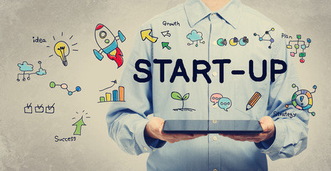 Start-up concept with young man holding a tablet