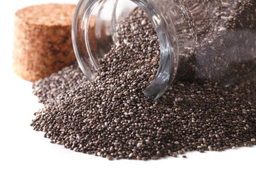 Selected Chia seeds spill out of a jar macro isolated on white. Horizontal
