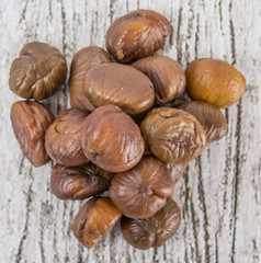 Roasted whole peeled chestnut over wooden background