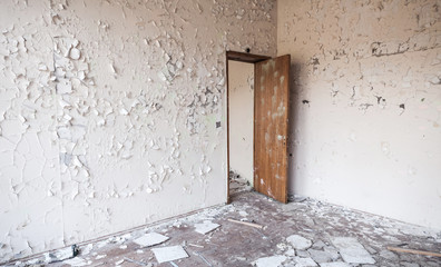 Cracked paint on walls and open wooden door