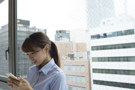 Women are using a smart phone at the window