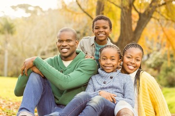 Portrait of a young family sitting in leaves