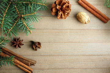 the branches of spruce with star anise and cinnamon on wooden brown background, Christmas composition.