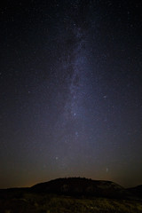Fototapeta na wymiar Starry sky and Milky Way on a background of hill.