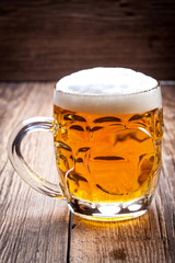Pint of beer on a wooden table.