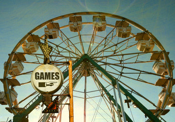 aged and worn vintage photo of carnival games sign with ferris wheel