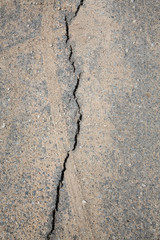 Close up asphalt road surface crack as long as fragile and heavy trucks passing