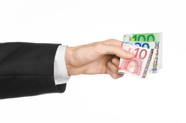 Money and business topic: hand in a black suit holding banknotes 10,20 and 100 euro on white isolated background in studio