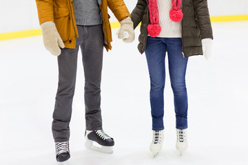close up of happy couple skating on ice rink