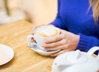 close up of woman with coffee cup at cafe