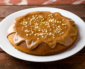 Pumpkin cake with caramel and peanuts on wooden table