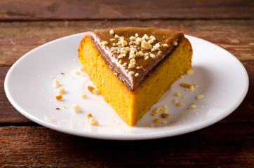 Pumpkin cake with caramel and peanuts on wooden table