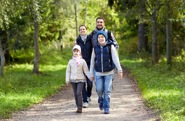 happy family with backpacks hiking