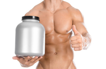 Bodybuilding and Sports theme: handsome strong bodybuilder holding a plastic jar with a dry protein...