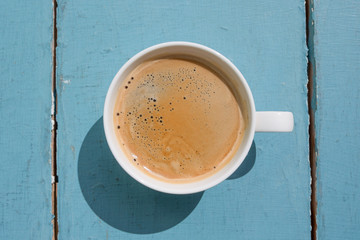 white coffee cup on blue wooden background