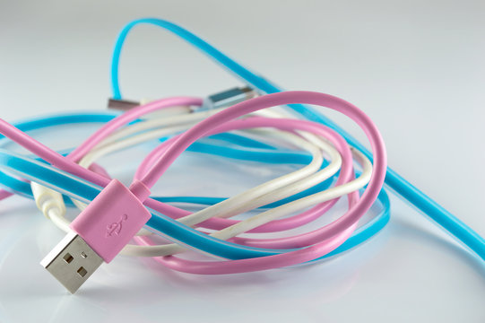 pink  blue and white USB cable on gray background