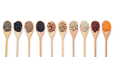 various dried legumes in wooden spoons