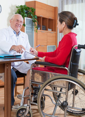  doctor discussing documents with disabled women.