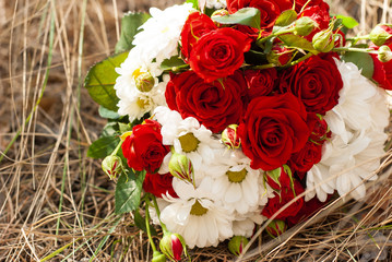 wedding bouquet of red roses on the grass
