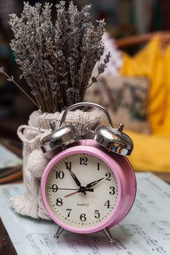 bouquet of lavender in the knitted vase and pink alarm clock