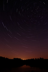 Smooth surface of the lake on a background the starry sky. Toned