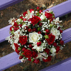 Wedding bridal bouquet lying on a park bench.