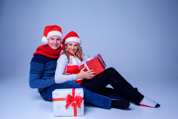 Obraz premium Lovely christmas couple sitting with presents