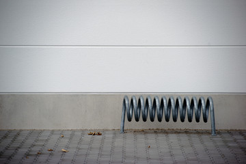 Spiralförmiger Fahrradständer / Ein spiralförmiger Fahrradständer vor einer Fassade 