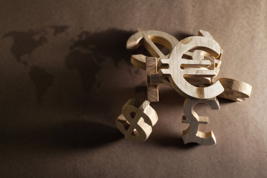 Wooden economy and currency units on craft background