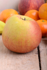 Fototapeta na wymiar Bananas apple mandarin peach strawberry on wooden background as health food concept
