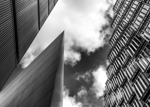 Black and white image of steel and glass skyscrapers of London against a cloudy sky