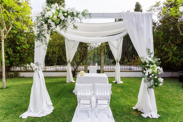 Silk tent for the wedding ceremony for the newlyweds. The garden in the countryside.