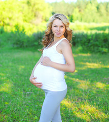 Fototapeta na wymiar Portrait smiling pregnant woman outdoors in summer day
