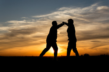 People Silhouette / Two men fighting in the sunset   